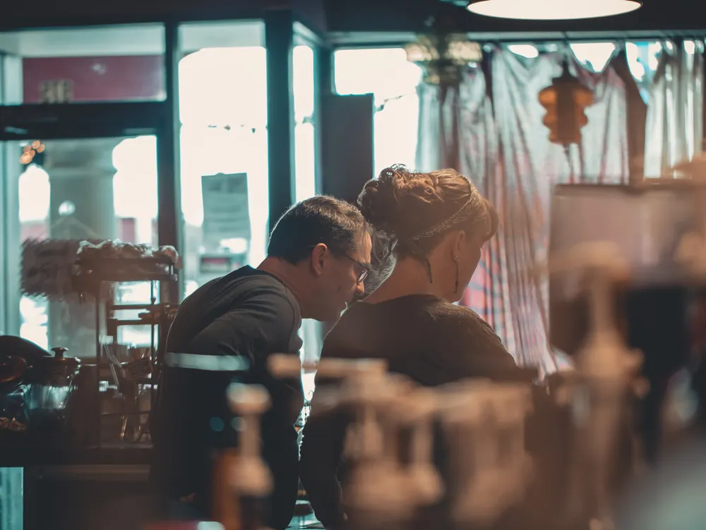 Two people going through their small business accounts together at a shop counter